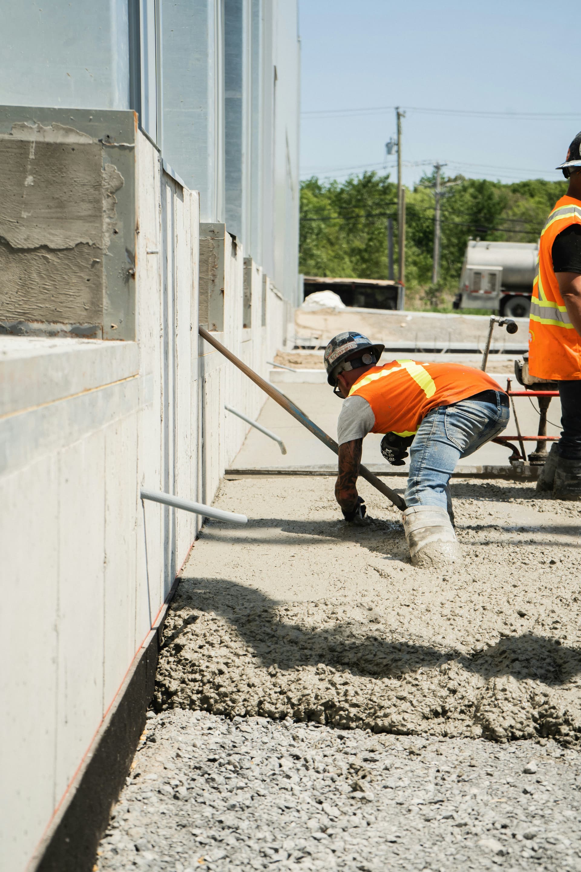 Placing concrete for a slab alongside a finished wall